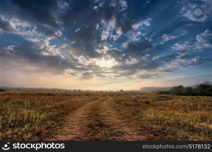 Summer rural landscape with sunrise and the road. Sunrise over the meadow