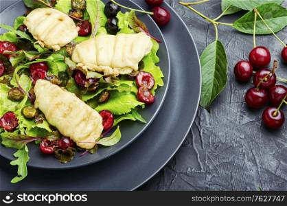Summer salad of leaf lettuce,fried halloumi cheese and cherry berries. Lettuce salad with cherries,halloumi