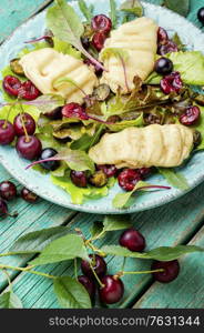 Summer salad of leaf lettuce,fried halloumi cheese and cherry berries. Summer green salad with berry.