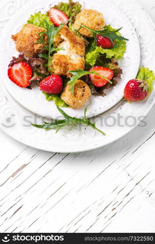 Summer salad with berries, leaf lettuce and grilled cheese. Summer meat salad with berries