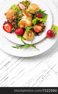 Summer salad with berries, leaf lettuce and grilled cheese. Summer meat salad with berries