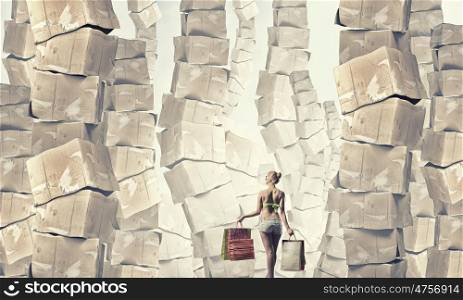 Summer sale. Beautiful young girl in bikini with shopping bags and pile of carton boxes