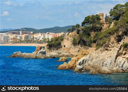Summer sea rocky coast view with Castle of Sant Joan (Sa Caleta beach, Lloret de Mar town, Spain). Peoples unrecognizable.