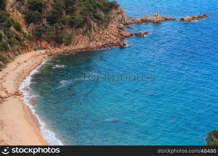 Summer sea rocky coast view with sandy Beach Cala del Senyor Ramon. Coastline between Barcelona and Palamos (Coasta Brava, Catalonia, Spain).