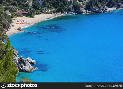 Summer sea sandy beach. Coastline between Barcelona and Palamos (Costa Brava, Catalonia, Spain). People are unrecognizable.