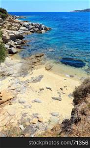 Summer sea scenery with aquamarine transparent water and sandy beach. View from shore (Sithonia, Halkidiki, Greece).