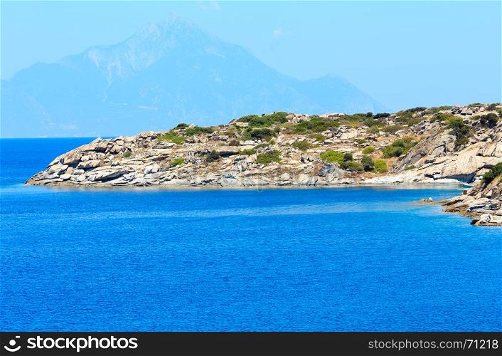 Summer sea scenery with aquamarine water and Athos Mount. View from shore (Sithonia, Halkidiki, Greece).