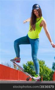 Summer sport and active lifestyle. Cool teenage girl in full length skater riding skateboard on the street. Outdoor.
