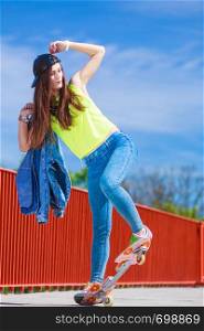 Summer sport and active lifestyle. Cool teenage girl skater riding skateboard on the street. Outdoor.