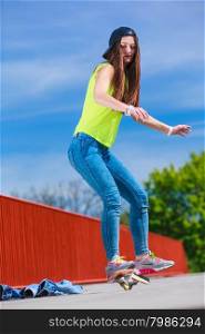 Summer sport and active lifestyle. Cool teenage girl skater riding skateboard on the street. Outdoor.