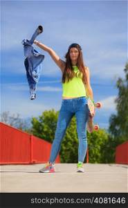 Summer sport and active lifestyle. Cool teenage girl skater with skateboard on the street. Outdoor.