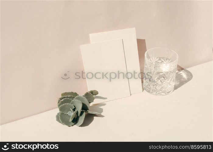 summer stationery mock-up scene. Blank business card, succulent and glass of clear water on beige textured table background.. summer stationery mock-up scene.