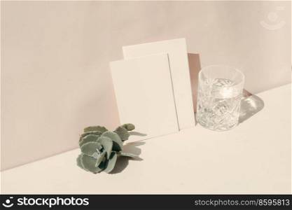 summer stationery mock-up scene. Blank business card, succulent and glass of clear water on beige textured table background.. summer stationery mock-up scene.