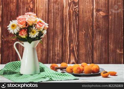 Summer still life with peaches and flowers on a wooden table. Summer still life