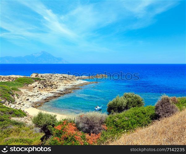 Summer stony sea coast landscape with Athos mount view in far (Halkidiki, Sithonia, Greece).