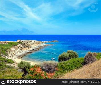 Summer stony sea coast landscape with Athos mount view in far (Halkidiki, Sithonia, Greece).