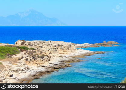 Summer stony sea coast landscape with Atthos mount view in far(Halkidiki, Sithonia, Greece).