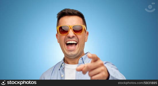 summer, style, emotions and people concept - face of laughing middle aged latin man in shirt and sunglasses over blue background