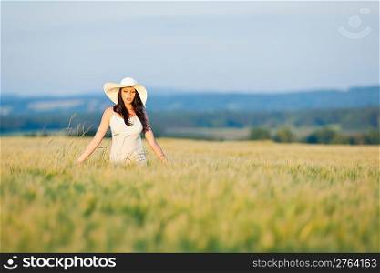 Summer sunset beautiful brunette woman walk in wheat corn field