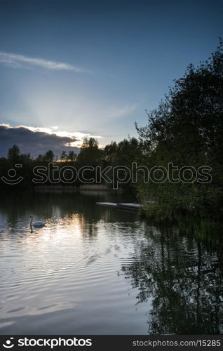 Summer sunset reflected in calm lake waters