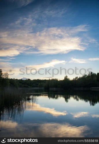 Summer sunset reflected in calm lake waters