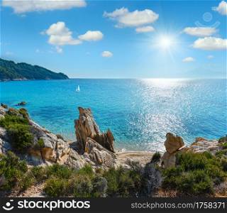 Summer sunshiny morning small sandy beach and rocky sea coast