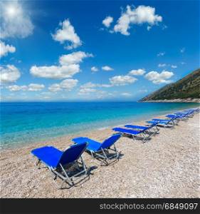 Summer sunshiny pebbly beach with sunbeds (Albania). Two shots stitch high resolution image.