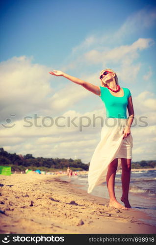 Summer time relax leisure concept. Attractive woman on the beach. Lady wearing sunglasses having fun on sunny day. Attractive woman on the beach.