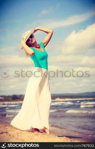 Summer time relax leisure concept. Attractive woman on the beach. Lady wearing sunglasses and hat. Attractive woman on the beach.