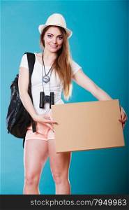 Summer tourism active lifestyle concept. Woman happy female tourist hitchhiking with blank sign cardboard on blue