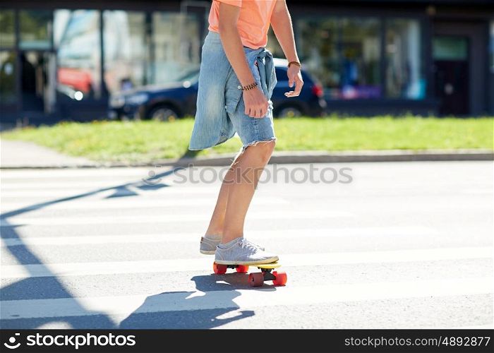 summer, traffic, extreme sport and people concept - teenage boy riding short modern cruiser skateboard on crosswalk in city