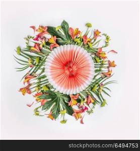 Summer tropical round flowers composition with palm leaves and orange paper party fan on white background