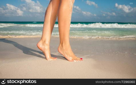 summer vacation and pedicure concept - closeup of woman legs walking on exotic beach sand. closeup of woman legs walking on beach sand