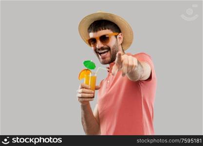 summer, vacation and people concept - happy smiling young man in sunglasses and straw hat with orange juice cocktail. happy man in straw hat with orange juice cocktail