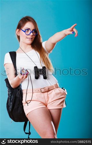 Summer vacation and tourism concept. Beauty woman long haired with backpack holding compass in hand on blue
