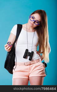 Summer vacation and tourism concept. Beauty woman long haired with backpack holding compass in hand on blue