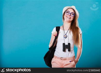 Summer vacation and tourism concept. Smiling woman in straw hat with backpack binocular compass on blue portrait