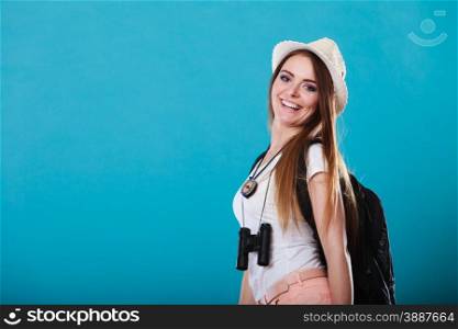 Summer vacation and tourism concept. Smiling woman in straw hat with backpack binocular on blue portrait