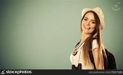Summer vacation and tourism concept. Smiling woman in straw hat with backpack binocular portrait