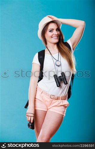Summer vacation and tourism concept. Young woman in straw hat with backpack binocular compass on blue portrait