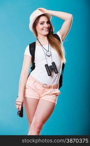 Summer vacation and tourism concept. Young woman in straw hat with backpack binocular compass on blue portrait