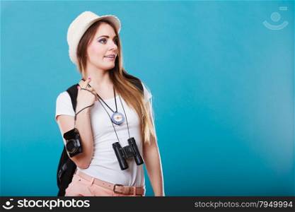 Summer vacation and tourism concept. Young woman in straw hat with backpack binocular compass on blue portrait