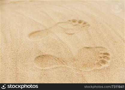 summer vacation concept - footprints in sand on beach. footprints in sand on summer beach