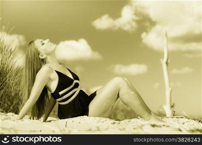 Summer vacation day freetime concept. Sitting woman body sunbathing delight on beach seaside.