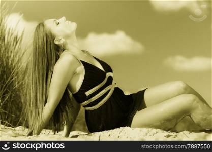 Summer vacation day freetime concept. Sitting woman body sunbathing delight on beach seaside.