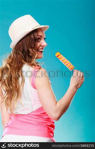 Summer vacation happiness concept. Smiling joyful and cheerful woman fashionable female model eating popsicle ice pop on blue background