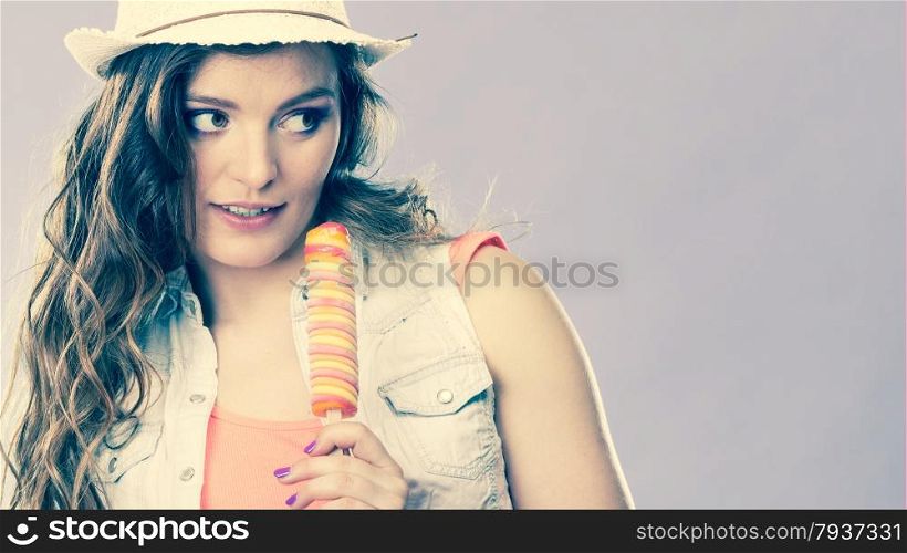 Summer vacation happiness concept. Smiling joyful and cheerful woman fashionable female model eating popsicle ice pop cross filter