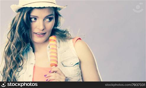 Summer vacation happiness concept. Smiling joyful and cheerful woman fashionable female model eating popsicle ice pop cross filter