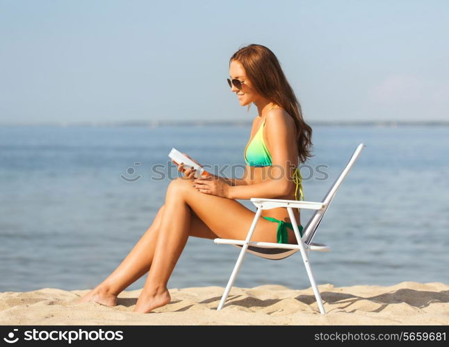 summer vacation, holidays and people concept - smiling young woman sunbathing in lounge on beach