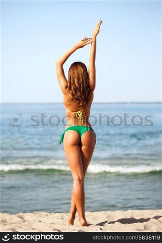 summer vacation, holidays and people concept - young woman sunbathing on beach